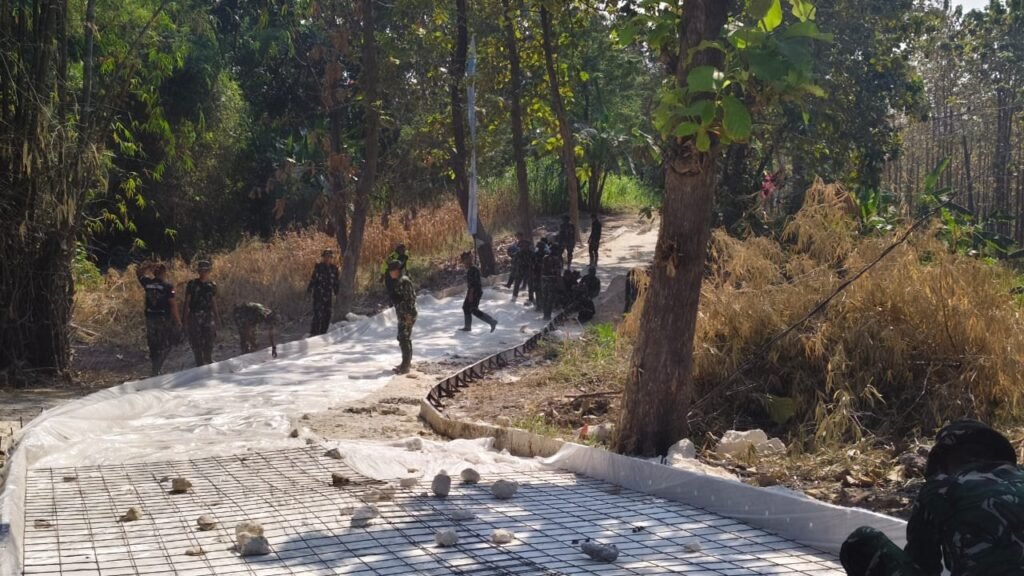 Kompak Bentangkan Plastik Alas Cor, Satgas TMMD dan Warga Perkuat Pondasi Jalan Rabat Beton Desa Tlemang
