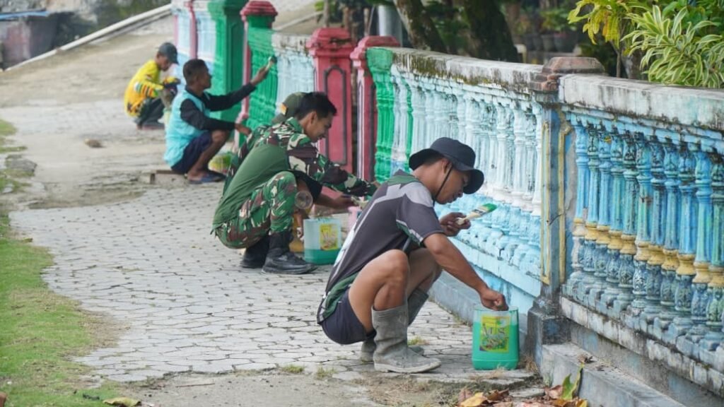 Satgas TMMD Bersama Warga Gotong Royong Cat Pagar di Desa Umbele Satgas TMMD Bersama Warga Gotong Royong Cat Pagar di Desa Umbele